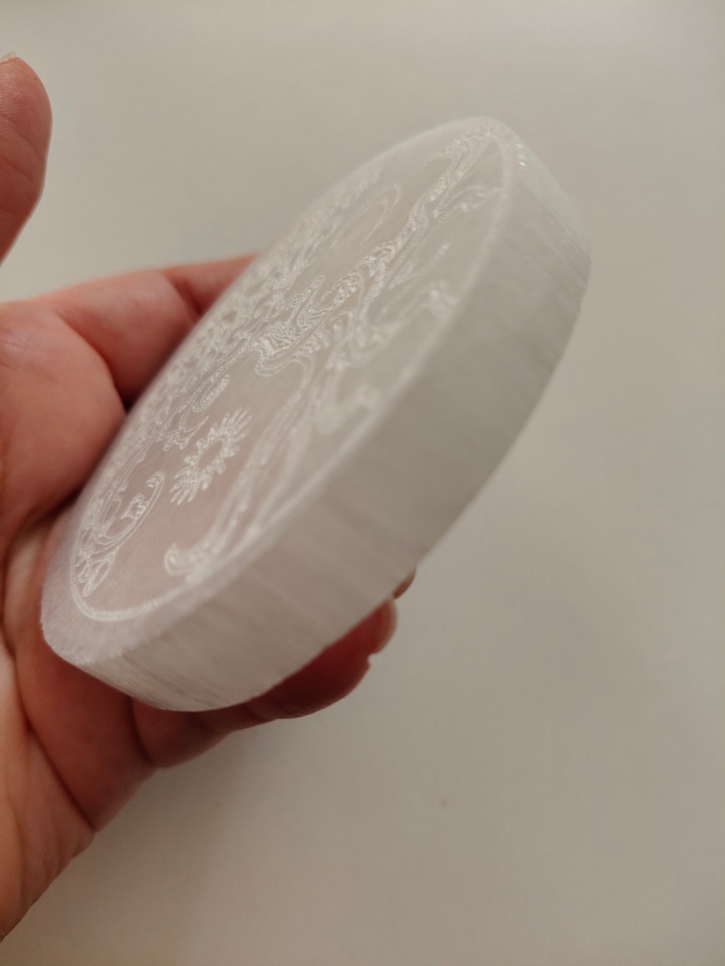 Socle en sélénite avec arbre, soleil et lune gravés. Poids : environ 148 g. Dimensions : largeur : 8 cm, hauteur : 1 cm.