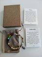Bracelet en larderite avec 7 pierres de chakra (comprend une boîte, un sac en velours et des cartes explicatives)