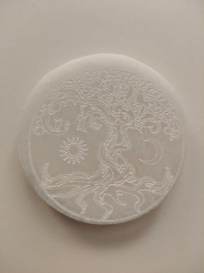 Socle en sélénite avec arbre, soleil et lune gravés. Poids : environ 148 g. Dimensions : largeur : 8 cm, hauteur : 1 cm.