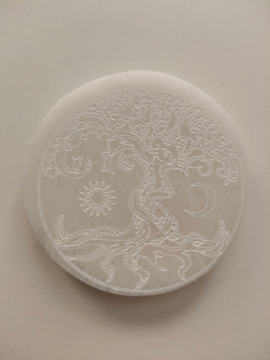 Socle en sélénite avec arbre, soleil et lune gravés. Poids : environ 148 g. Dimensions : largeur : 8 cm, hauteur : 1 cm.